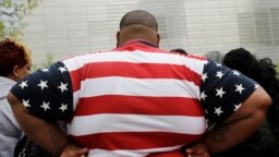 Seorang pria dengan kelebihan berat badan mengenakan baju dengan pola bendera AS ketika berkunjung ke World Trade Center, New York, pada 8 Mei 2014. Hampir 42 persen orang dewasa di AS mengalami obesitas. (Foto: AP/Mark Lennihan)