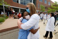 FILE - Medical students hug during a demonstration, June 5, 2020, in Salt Lake City, Utah.