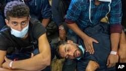 FILE - Migrants wait aboard of the Norway-flagged Geo Barents rescue ship for Italian authorities to decide wether they will be allowed to disembark, in Catania's port, Sicily, southern Italy, November 8, 2022.