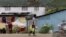 FILE - A man carries containers filled with gasoline to sell on the streets in Cap-Haitien, Haiti, April 29, 2024.