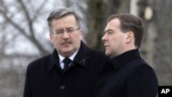 Poland's President Bronislaw Komorowski (l) and Russia's President Dmitry Medvedev during a ceremony marking the one-year anniversary of the Polish presidential plane crash at the crash site near Smolensk, western Russia, April 11, 2011
