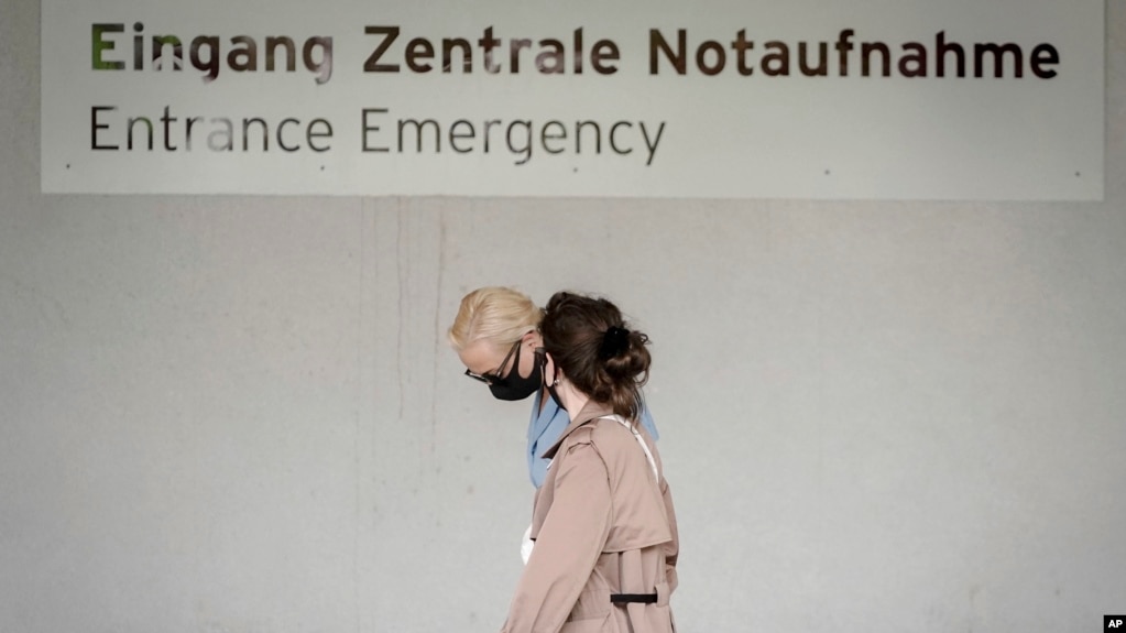 Alexei Navalny's wife Yulia, background, arrives at the Charite hospital in Berlin, Germany, Monday, Aug. 24, 2020. Russian oppositional Alexej Nawalny is being treated at the hospital by German doctors after a suspected poisoning. (Kay Nietfeld/dpa via AP)