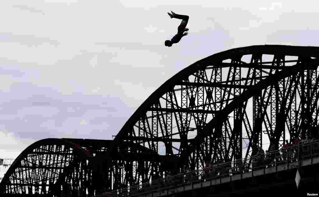 A participant jumps into the Vltava river during a high diving competition in Prague, Czech Republic, Aug. 22, 2020.