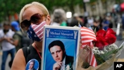 Anma törenine katılan Diane Massaroli, elinde, 11 Eylül 2001 saldırıları sonucu New York'ta hayatını kaybeden eşi Michael Massaroli'nin fotoğrafını tutuyor. 