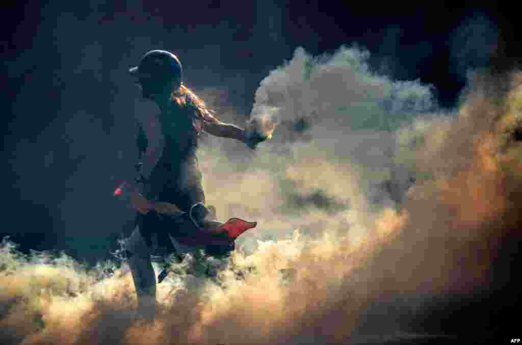 Venezuelan opposition activists clash with the riot police during a rally against the government of President Nicolas Maduro, in Caracas.