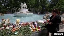 一名婦女在克里米亞塞瓦斯托波爾參觀為俄羅斯當局所說的烏克蘭飛彈襲擊受害者設立的臨時紀念地。(2024年6月24日)