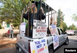 Para peserta unjuk rasa memprotes beban pinjaman pendidikan bersiap menggelar aksi di Ashland, Oregon, 4 Juli 2019. (Foto: Reuters)