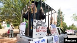 Para peserta unjuk rasa memprotes beban pinjaman pendidikan bersiap menggelar aksi di Ashland, Oregon, 4 Juli 2019. (Foto: Reuters)