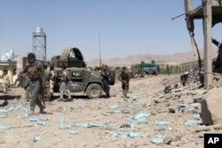 FILE - In this June. 18, 2017, photo, security forces are deployed to the site of a suicide attack between Taliban insurgents and government forces near the main police station in eastern Paktia province, Afghanistan.