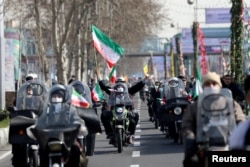 Warga Iran mengendarai sepeda motor saat berpartisipasi dalam perayaan 42 tahun Revolusi Islam di Teheran, Iran 10 Februari 2021. (Foto: Majid Asgaripour/WANA via REUTERS)