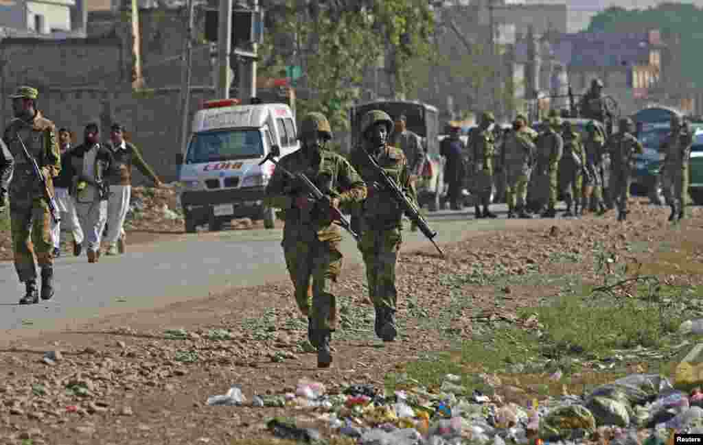 Pakistani army soldiers run towards a gun battle with Taliban militants near Peshawar's airport, December 16, 2012.