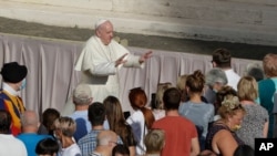 Pope Francis asks the faithful to keep safety distance as he arrives during his weekly general audience in San Damaso courtyard at the Vatican, Sept. 9, 2020.