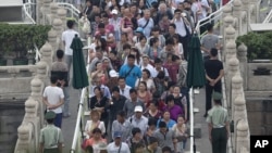 Visitors walk past the plain clothes policemen and paramilitary policemen as they enter Tiananmen Gate in Beijing, June 4, 2013.