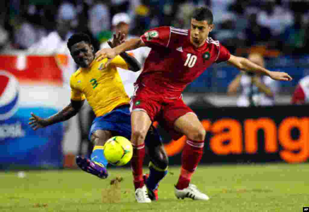 Morocco's Belhanda fights for the ball with Gabon's Mouele during their African Cup of Nations soccer match in Libreville