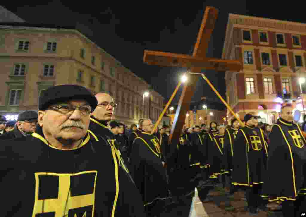 Waumini wakibeba Msalaba wakipita Njia ya Msalaba mjini Warsaw, Poland, Ijuma, April 3, 2015.