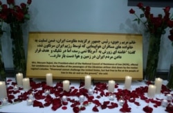 Candles and flowers are displayed with condolences offered to the families of the passengers of the Ukrainian jetliner shot down by Iran by accident at a memorial at the "2020 LA Convention for Free Iran," Jan. 11, 2020.
