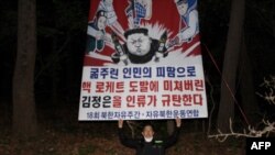 Park Sang-hak melepaskan spanduk bergambar kartun Pemimpin Korea Utara Kim Jong-un yang terpasang pada balon, di lokasi yang dirahasiakan dekat zona demiliterisasi (DMZ) yang memisahkan Korut dengan Korsel, 30 April 2021. (Foto: Handout / Fighters for a Free North Korea / AFP)