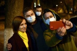 Moldova's presidential candidate Maia Sandu, poses for a selfie photo with her supporters as she leaves the Action and Solidarity Party office in Chisinau, Nov. 16, 2020.