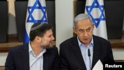 ARCHIVO - El primer ministro israelí, Benjamin Netanyahu, habla con el ministro de Finanzas, Bezalel Smotrich, durante la reunión semanal del gabinete en el Ministerio de Defensa en Tel Aviv, Israel, el 7 de enero de 2024. 