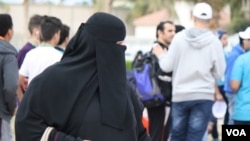 FILE - A woman walks among a group of men in Jeddah, Saudi Arabia, Jan. 28. 2016. (H. Murdock/VOA) 