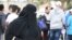FILE - A woman walks among a group of men in Jeddah, Saudi Arabia, Jan. 28. 2016. (H. Murdock/VOA) 