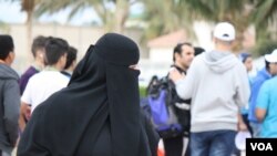 FILE - A woman wears a mandatory abaya, or loose-fitting gown, over her clothes in Jeddah, Saudi Arabia, Jan. 28. 2016. Rumors are circulating that a mixed-gender nightclub that does not require women to wear loose robes has opened in the city. (H. Murdock/VOA)