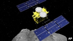 Gambar grafik komputer yang dirilis oleh Japan Aerospace Exploration Agency (JAXA) ini menunjukkan pesawat luar angkasa Hayabusa2 di atas asteroid Ryugu. (ISAS / JAXA melalui AP)