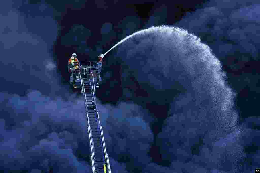 Firefighters extinguish a fire at a plastic factory in Ladenburg, Germany.