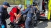 Police officers and medical workers treat a wounded local resident after a Russian air strike, amid Russia's attack on Ukraine, in Kharkiv, Ukraine, April 9, 2024.