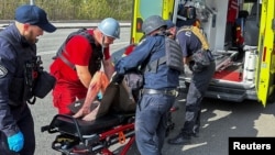 Agentes de policía y trabajadores médicos tratan a un residente local herido tras un ataque aéreo ruso, en medio de la guerra entre Rusia a Ucrania, en Kharkiv, Ucrania, el 9 de abril de 2024.