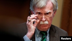 FILE - Then-national security adviser John Bolton adjusts his glasses during an Oval Office meeting at the White House in Washington, April 2, 2019.