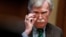 FILE - Then-national security adviser John Bolton adjusts his glasses during an Oval Office meeting at the White House in Washington, April 2, 2019.