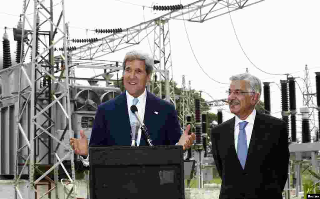 John Kerry speaks alongside Pakistan's Minister for Water and Power Khawaja Asif during their visit to an Islamabad electric supply company substation, August 1, 2013.