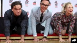 Johnny Galecki, izquierda, Jim Parsons y Kaley Cuoco, miembros del elenco de la serie de televisión "The Big Bang Theory" colocan sus manos en el cemento durante una ceremonia en el Teatro Chino TCL el miércoles 1 de mayo de 2019 en Los Angeles (Willy Sanjuan/Invision/AP).