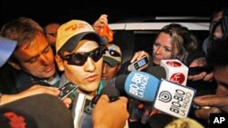 Rescued miner Carlos Mamani, from Bolivia, is surrounded by the press as he arrives to his home in Copiapo, Chile, 14 Oct. 2010