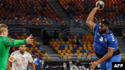 Gauthier Mvumbi de la RDC tente un shoot face au gardien du Danemark lors du Mondial de Handball, Egypte, le 17 janvier 2021.