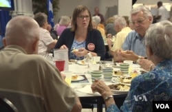 Democrat Emily Cain, a former Maine state senator and now a candidate for the U.S. House of Representatives, meets with prospective voters over lunch at the Franco-American Center in Lewiston, Maine.