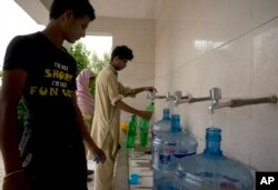People at a filtration plant fill their bottles with water from a tube well, in Islamabad, Pakistan, Aug. 23, 2017. A new study suggests some 50 million Pakistanis could be at risk of drinking arsenic-tainted groundwater.