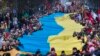 Величезний український прапор на знак протесту проти російського вторгнення в Україну під час святкування незалежності Литви у Вільнюсі, 11 березня 2023 р. AP Photo/Mindaugas Kulbis