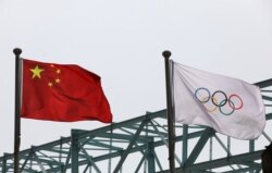 La bandera nacional china ondea junto a una bandera olímpica en el Comité Organizador de los Juegos Olímpicos y Paralímpicos de Invierno de 2022 en Beijing, el 30 de marzo de 2021.