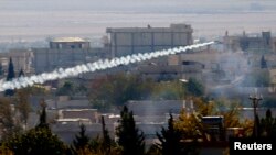 FILE - A rocket believed to have been launched by Islamic State forces flies from the east to the west side of the Syrian town of Kobani during fighting, Nov. 6, 2014 Picture taken from the Turkish side of the Turkey-Syria border. 