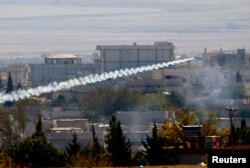 FILE - A rocket believed to have been launched by Islamic State forces flies from the east to the west side of the Syrian town of Kobani during fighting, Nov. 6, 2014. Picture taken from the Turkish side of the Turkey-Syria border.