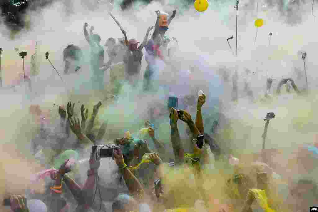 Runners dance covered in colored powder after taking part in the Color Run of Caracas, Venezuela.