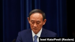 ဂျပန် ဝန်ကြီးချုပ် Yoshihide Suga ကိုဗစ်ထိန်းချုပ်ရေးညီလာခံတခု မှာ စကားပြောစဉ် (ဓာတ်ပုံ - Reuters)
