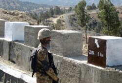 FILE - A Pakistani soldier stands guard at a border fence between Pakistan and Afghanistan, at Angore Adda, Pakistan, Oct. 18, 2017.