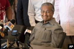 FILE - Mahathir Mohamad smiles during a press conference in Kuala Lumpur, Malaysia, May 10, 2018.