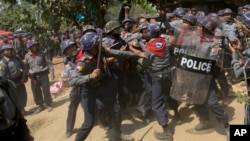 Police officers beat a student protester after detaining him following a crackdown in Letpadan, 140 kilometers (90 miles) north of the country's main city Yangon, Myanmar, Tuesday, March 10, 2015.