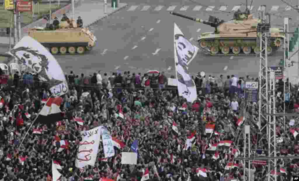 Egyptian army tanks, center, secure the perimeter of the presidential palace while protesters gather, chanting anti president Mohammed Morsi slogans, in Cairo, Egypt, Friday, Dec. 7, 2012.(AP Photo/Hassan Ammar)