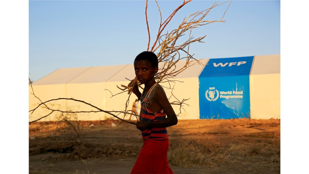 Seorang pengungsi Ethiopia yang melarikan diri dari pertempuran yang sedang berlangsung di wilayah Tigray, berjalan melewati tenda program pangan dunia, di kamp Um-Rakoba, di perbatasan Sudan-Ethiopia, negara bagian Al-Qadarif, Sudan, 23 November 2020. (REUTERS)