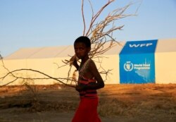 Seorang pengungsi Ethiopia yang melarikan diri dari pertempuran yang sedang berlangsung di wilayah Tigray, berjalan melewati tenda program pangan dunia, di kamp Um-Rakoba, di perbatasan Sudan-Ethiopia, negara bagian Al-Qadarif, Sudan, 23 November 2020. (REUTERS)